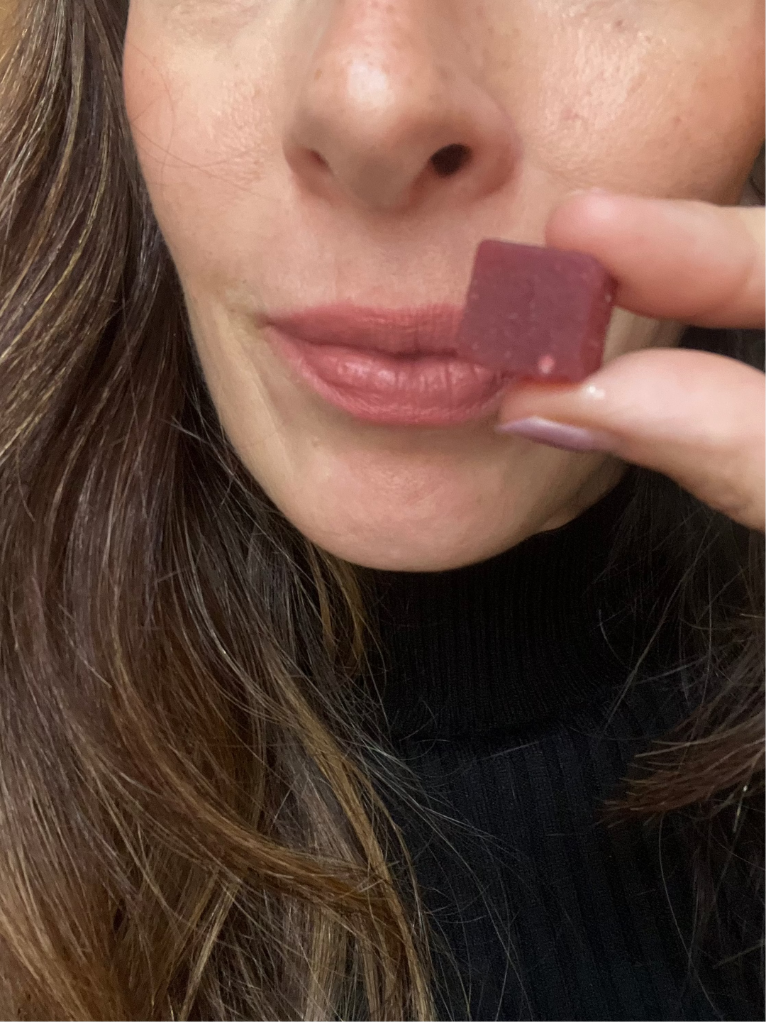 Person holding a shilajit gummy on the .and and getting ready to eat it.