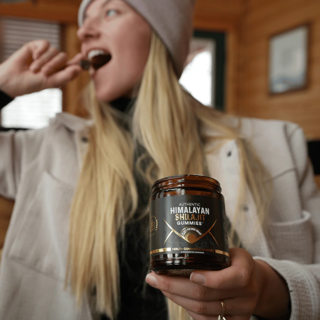 Person holding a jar of Himalayan Shilajit Gummies and eating something else.