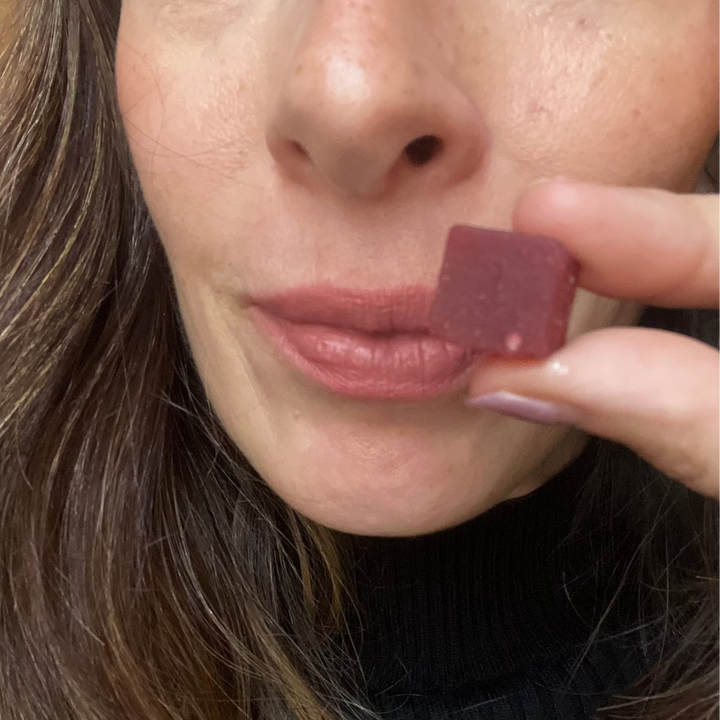 Person holding a shilajit gummy on the .and and getting ready to eat it. 